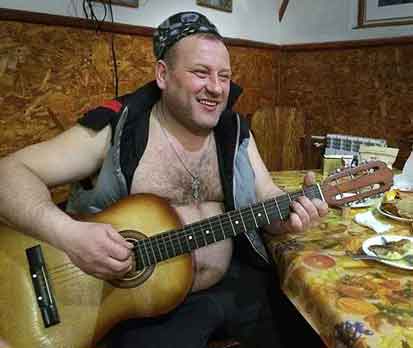 Vlad Klekner plays guitar during snowmobile trip in Russia