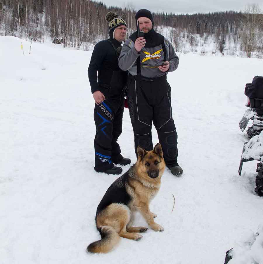 Igor Zapivalov and Evgeniy Borodin prepare for snowmobile trip with satellite phone.