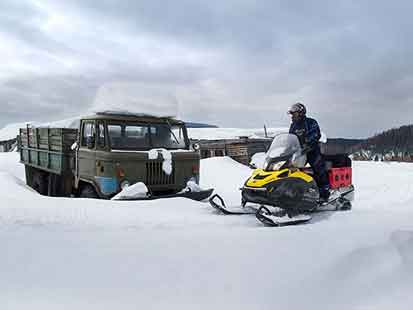 Snowmobile the Russia ghost town of Bolshaya at Oslyanka Mountain.