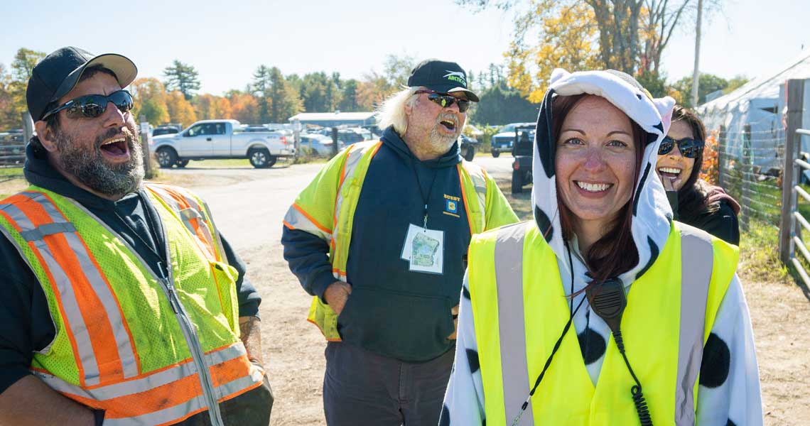 Snowmobile volunteers laughing at NH Grass Drags race.