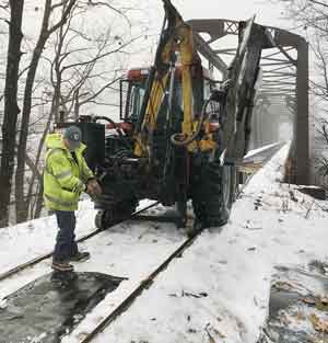 The NH Bureau of Trails use a tractor to prepare railroad trestle