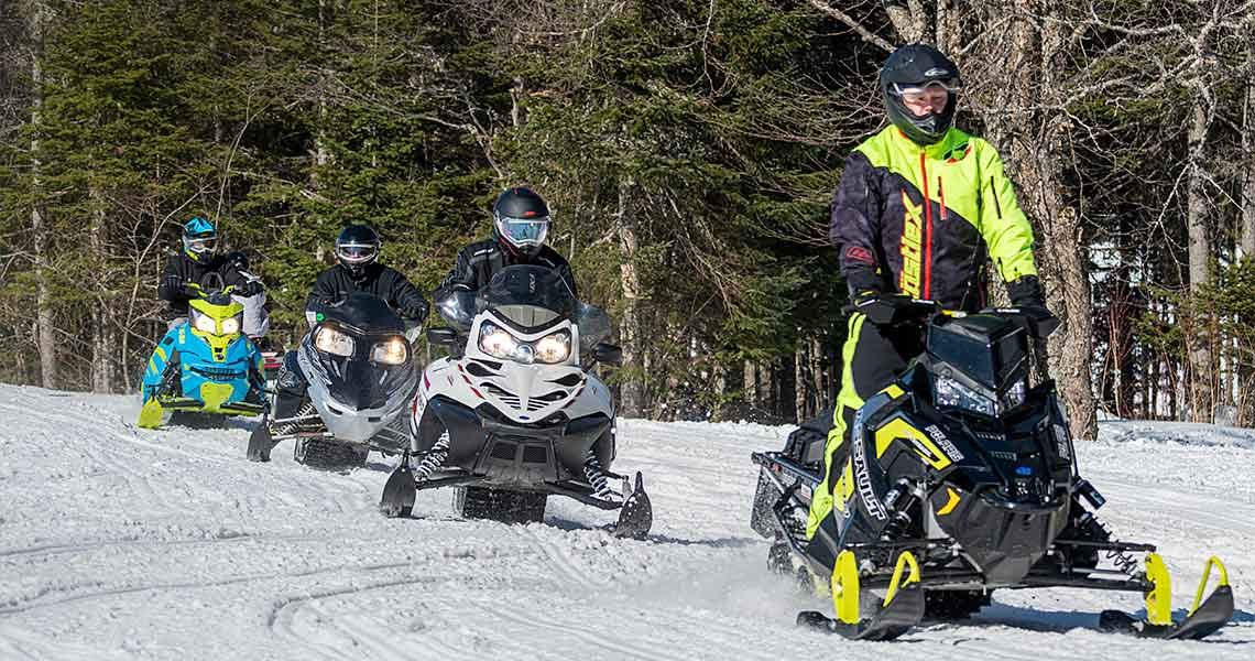 Snowmobile riders safely follow in line