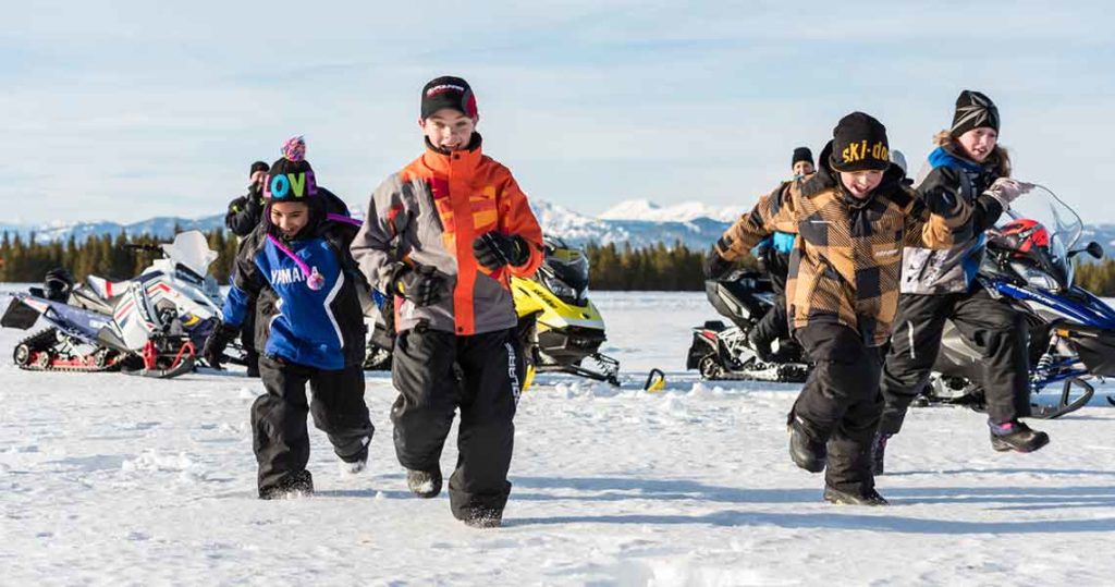 Children snowmobiling and having fun in winter