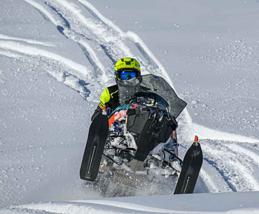 JP Bernier Alaska snowmobiler tour guide jumps snowmobile