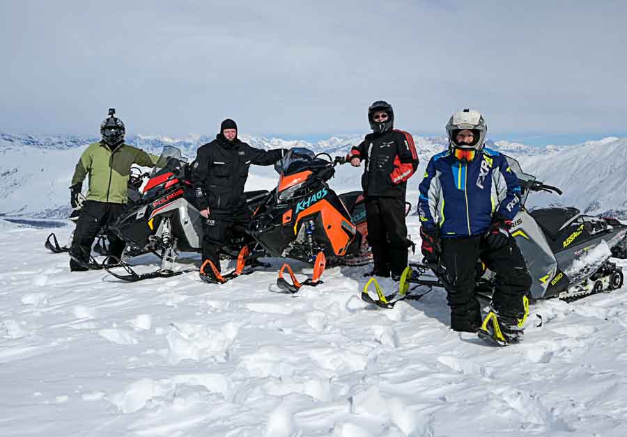 Dan Gould, Chris Gamache, Roger Wright and Gary Broderick snowmobile Alaska mountains.