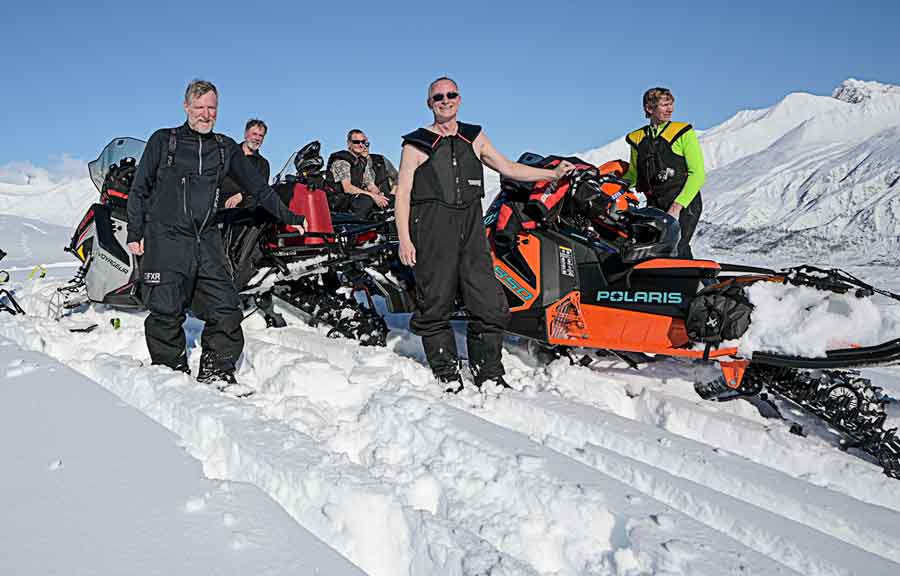 Dan Gould and Roger Wright snowmobile Alaska mountains.