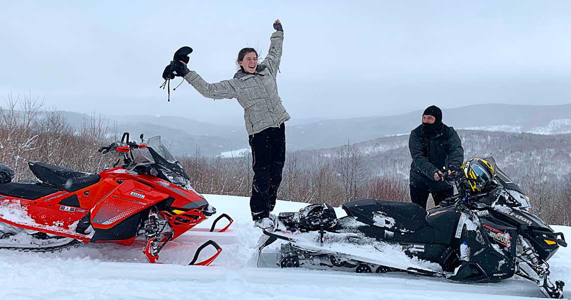 Woman celebrates snowmobiling in New Hampshire