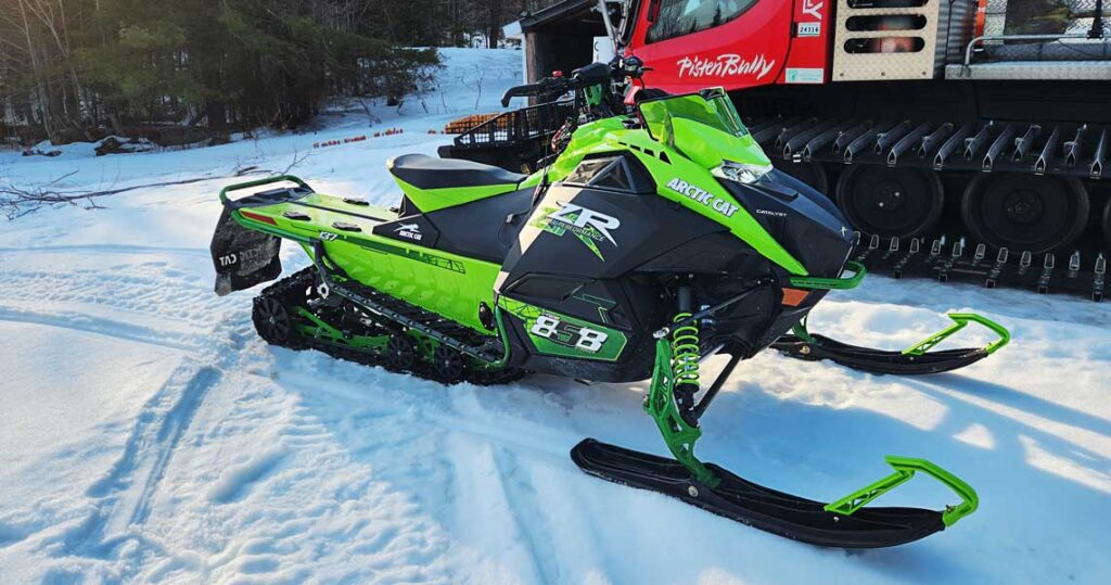 Arctic Cat Catalyst 858 vs 600 snowmobile test shows parked green snowmobile.